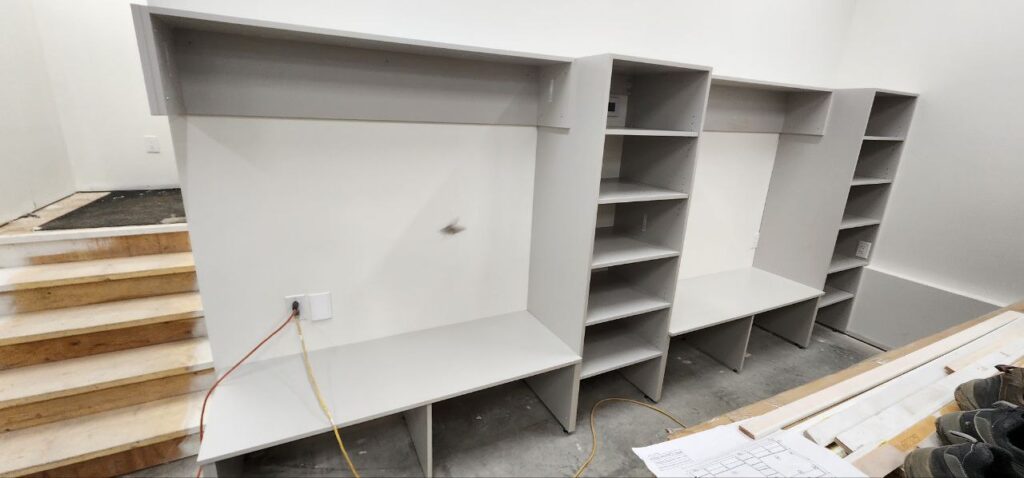 White and grey cabinets installation in a basement