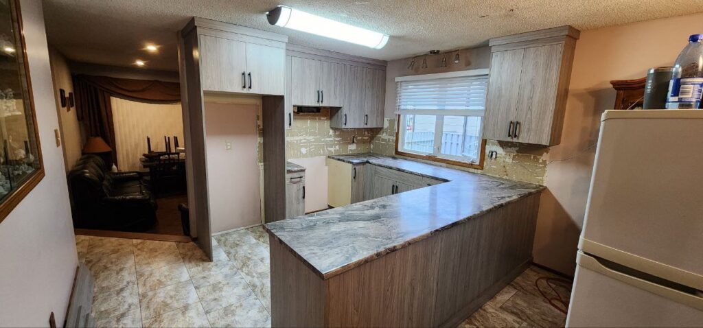 wooden kitchen cabinets with marble countertops.